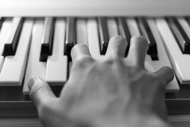 ピアノを弾く右手のモノクロ画像