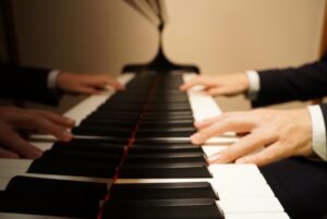 ピアノを弾く手と鍵盤の画像