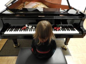 グランドピアノに座る女の子の写真