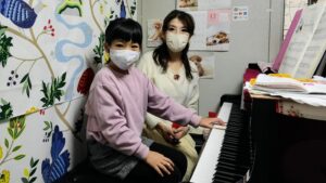 ピアノの先生と女の子がいっしょに連弾する写真の画像