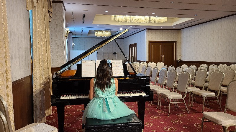グリーンのドレスを着てピアノを弾く女の子の画像