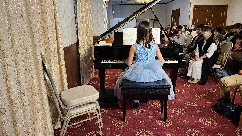 水色のドレスを着てピアノを弾く女の子の画像