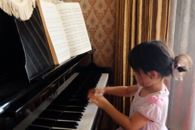 お家でピアノの練習をする女の子の画像