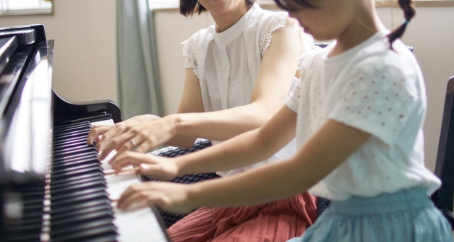 ピアノレッスンを受ける先生と子供の画像
