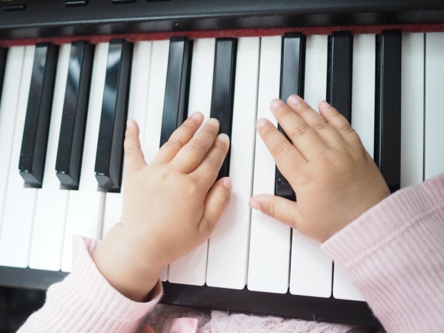 ピアノを弾く女の子の手と鍵盤の画像