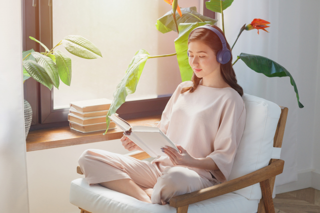 音楽を聴きながら勉強する女性の画像