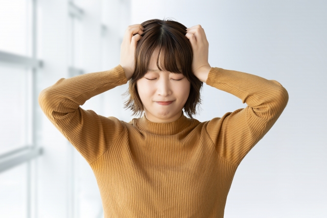 頭を抱える女性の画像