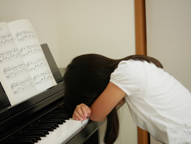 ピアノにひれ伏す女性の画像